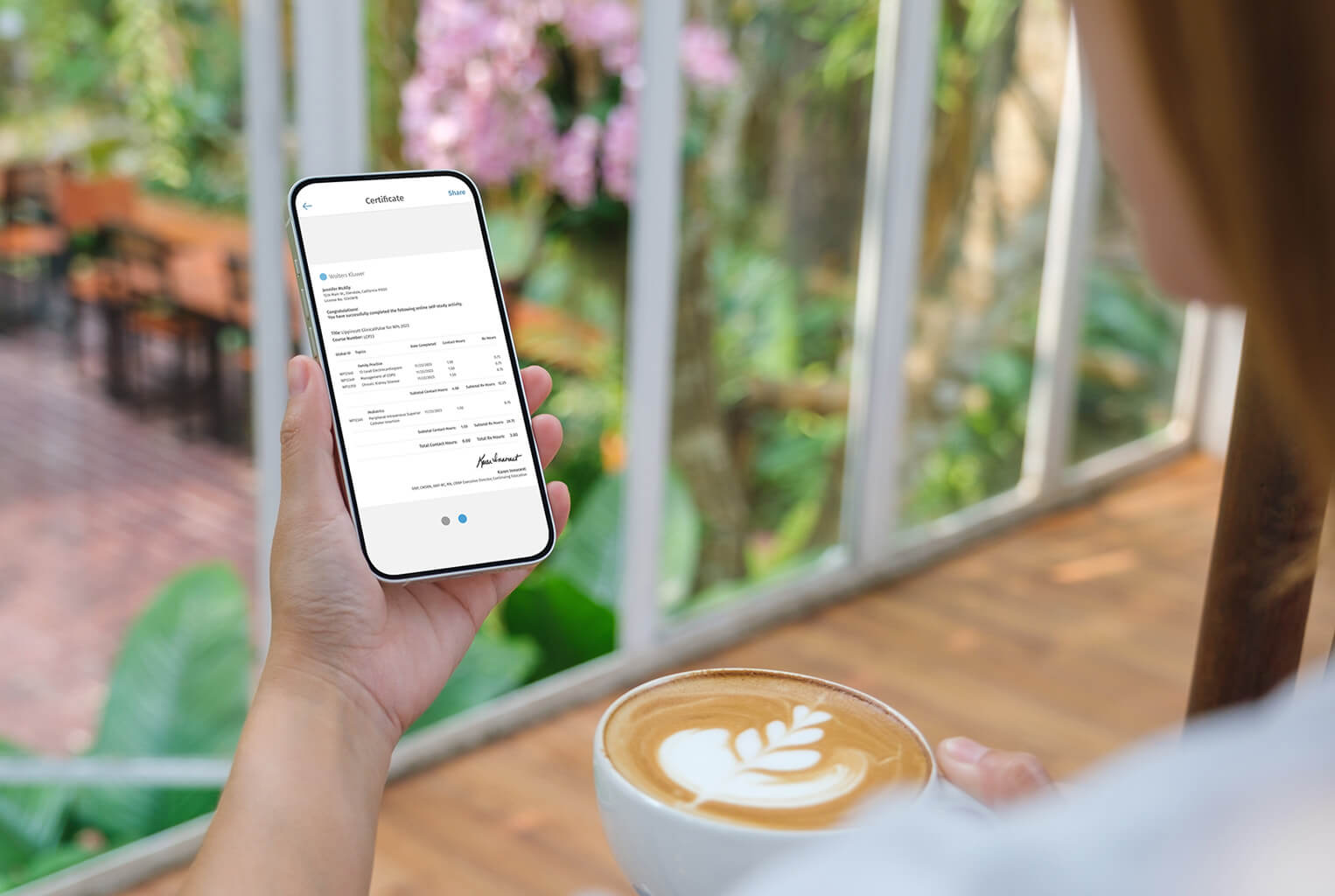 Woman at garden cafe looking at mobile app certificate